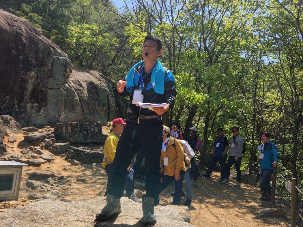 The guide leading a hiking group on a granite outcrop